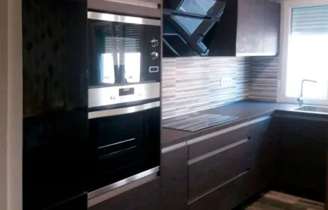 Cocina de estilo moderno con acabados en madera oscura.